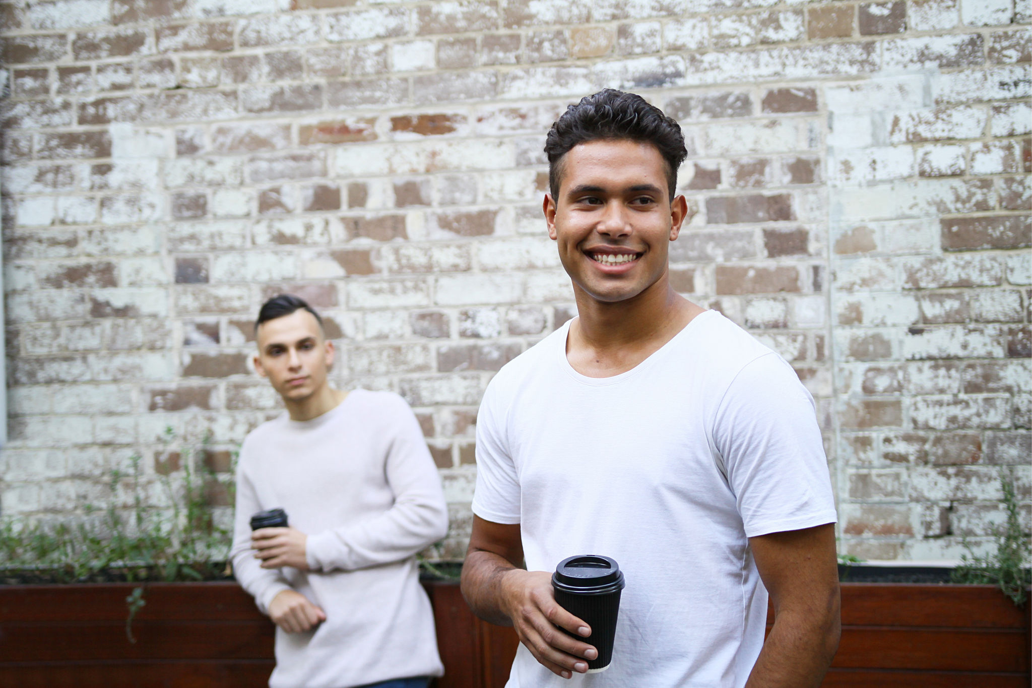 Two male friends enjoying takeaway coffees