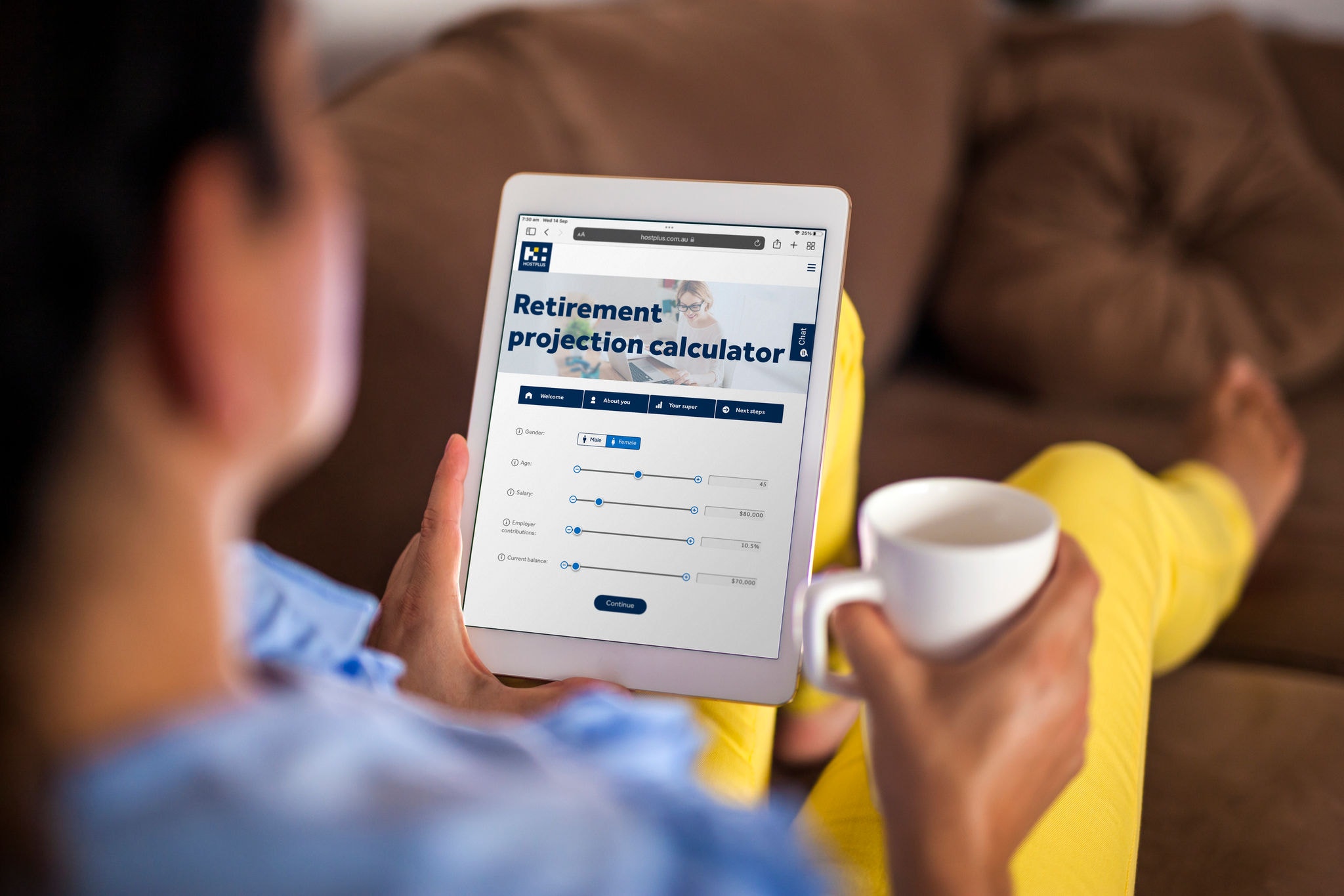 Woman lying down Sofa At Home Looking At Digital Tablet