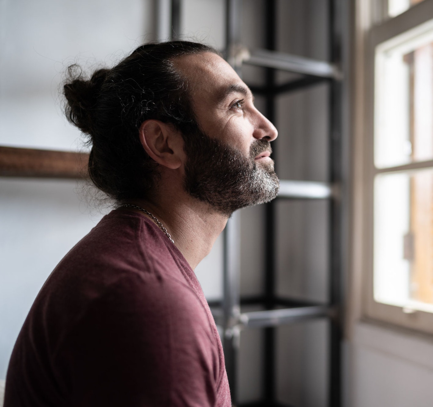 Man looking through the window at home
