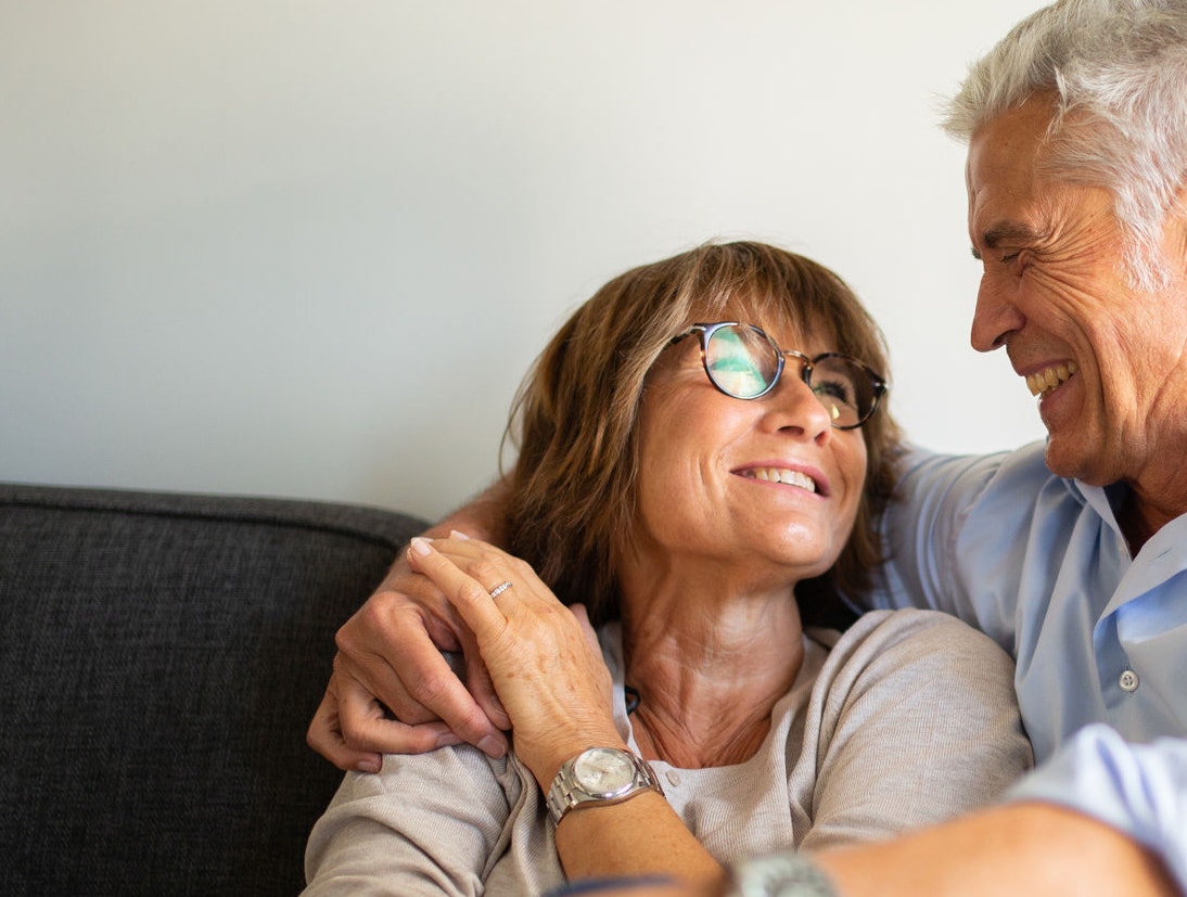 Portrait loving older couple sitting on sofa 