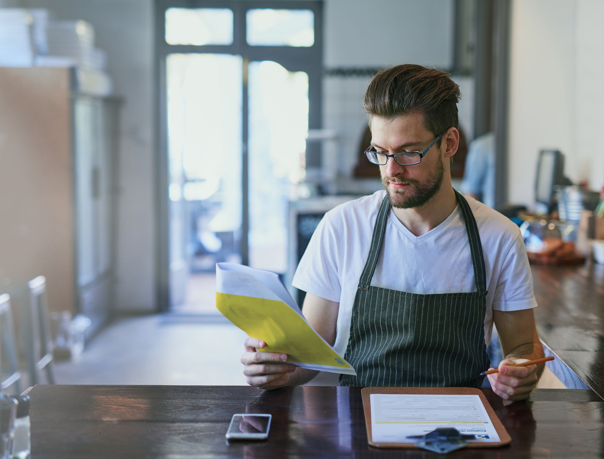 Young male barista working in his cafe