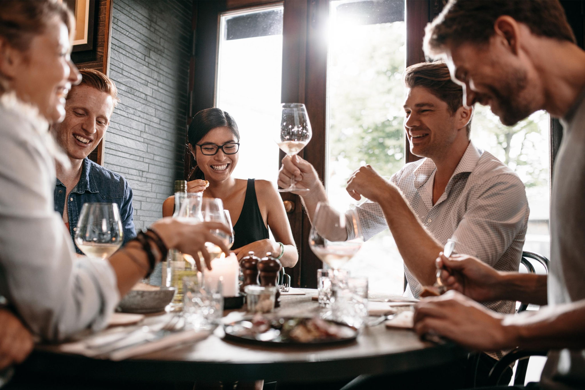 Friends enjoying wine and a meal at a restaurant