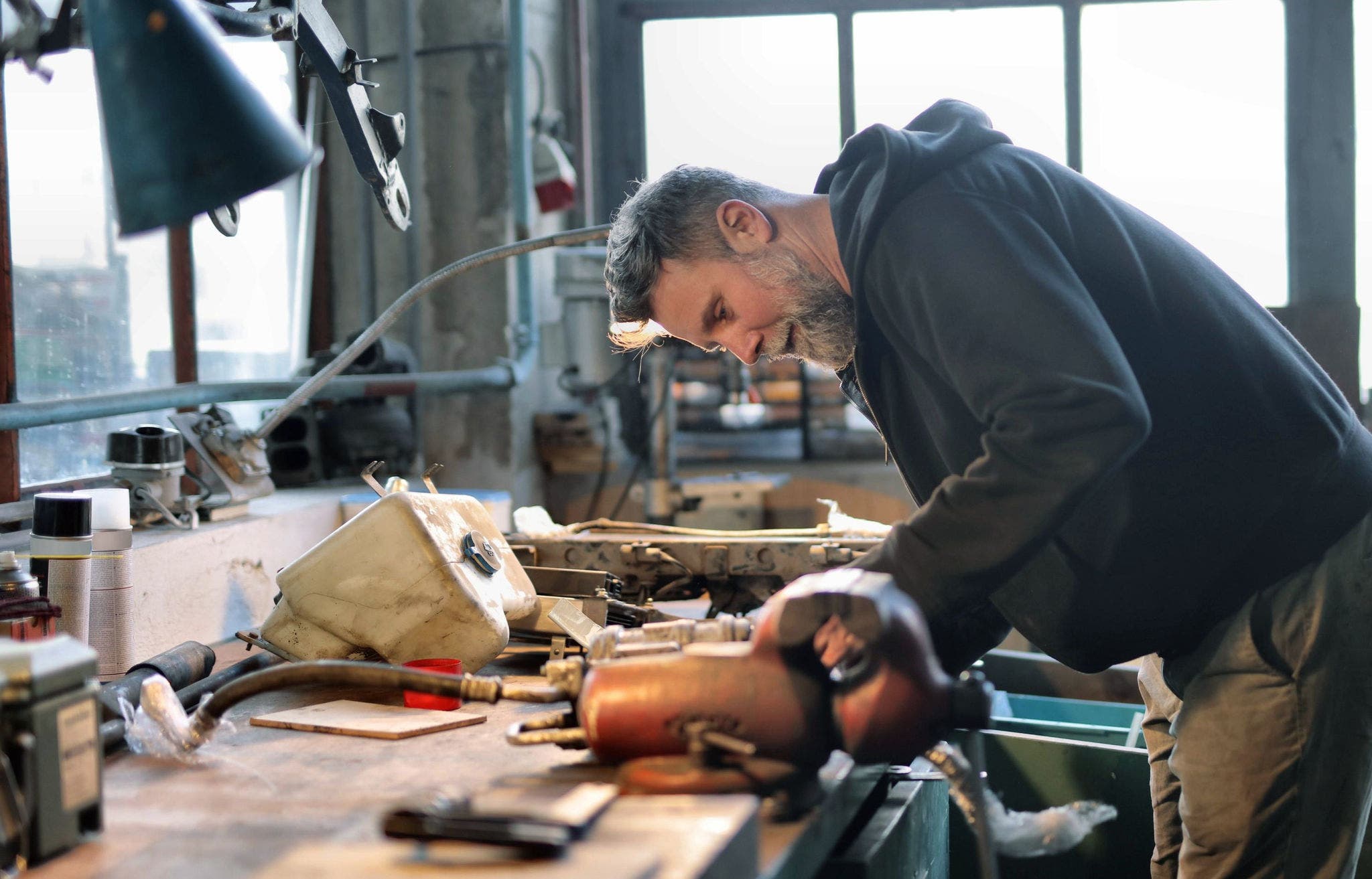 canva-smiling-mechanic-repairing-details-garage