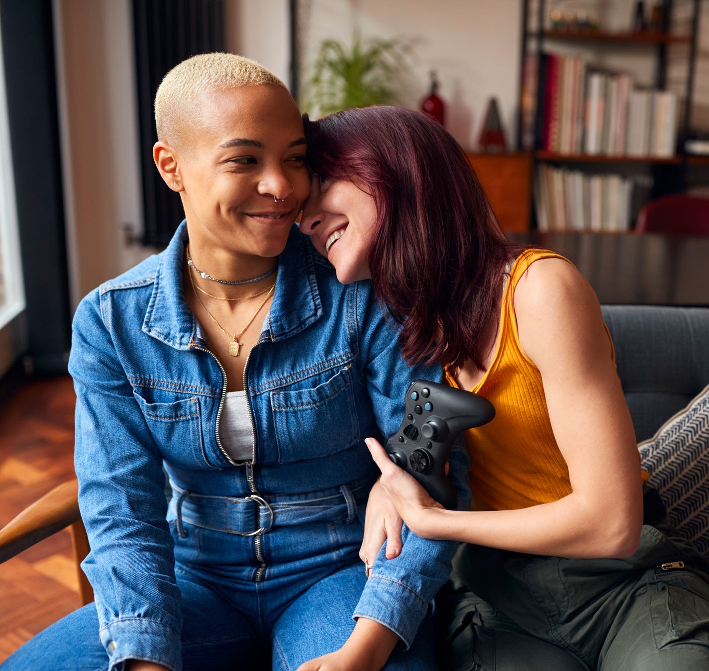 Female couple sitting on sofa gaming 