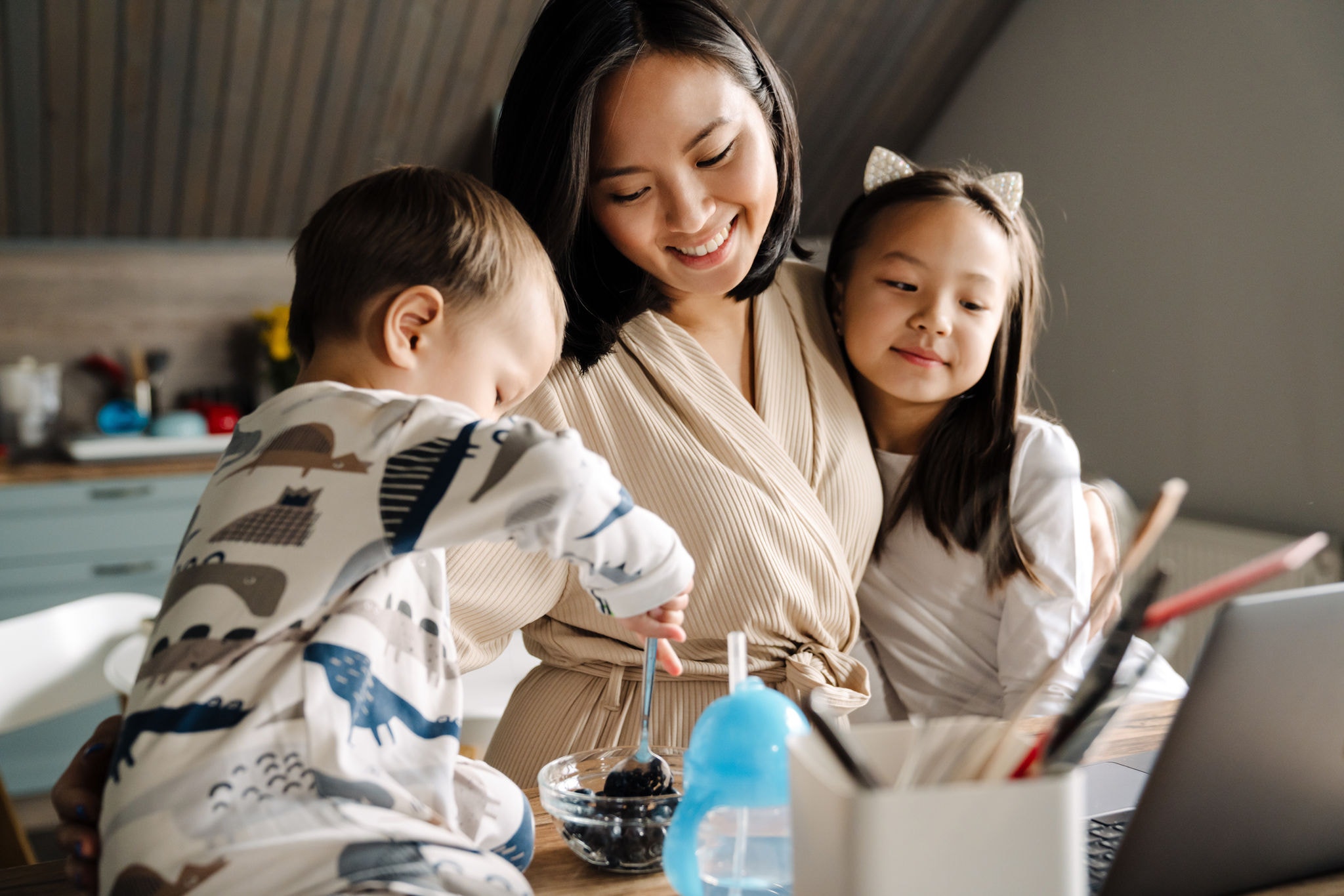 Happy asian family smiling and using laptop while spending time together at home