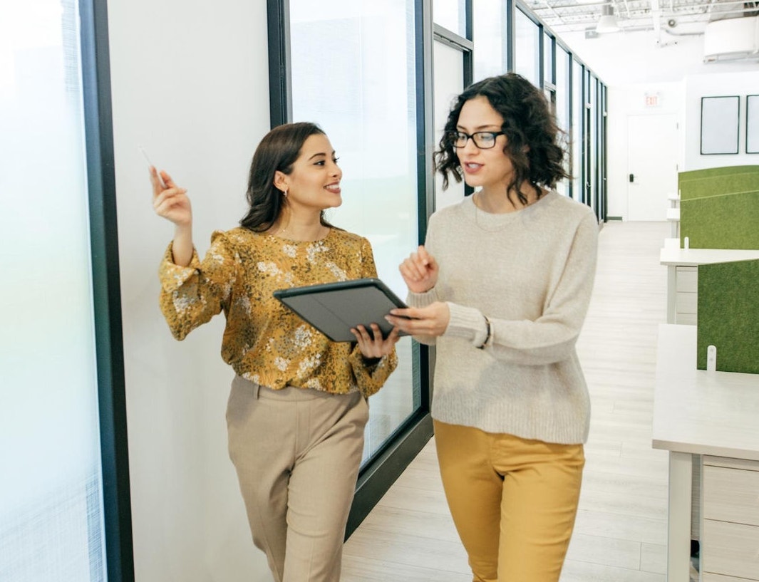Female workers walking in office discussing work