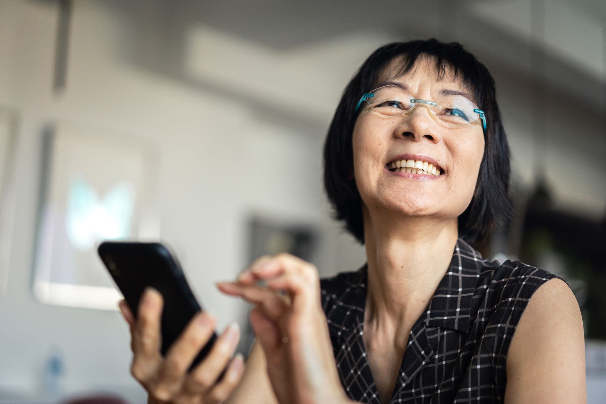 Woman laughing when using a smartphone