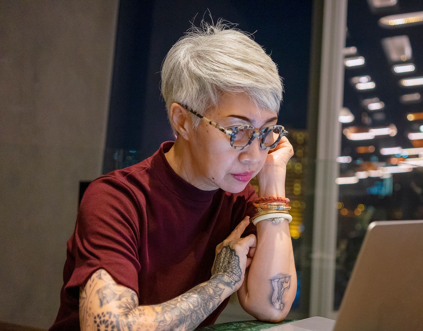 Senior woman working on laptop at night