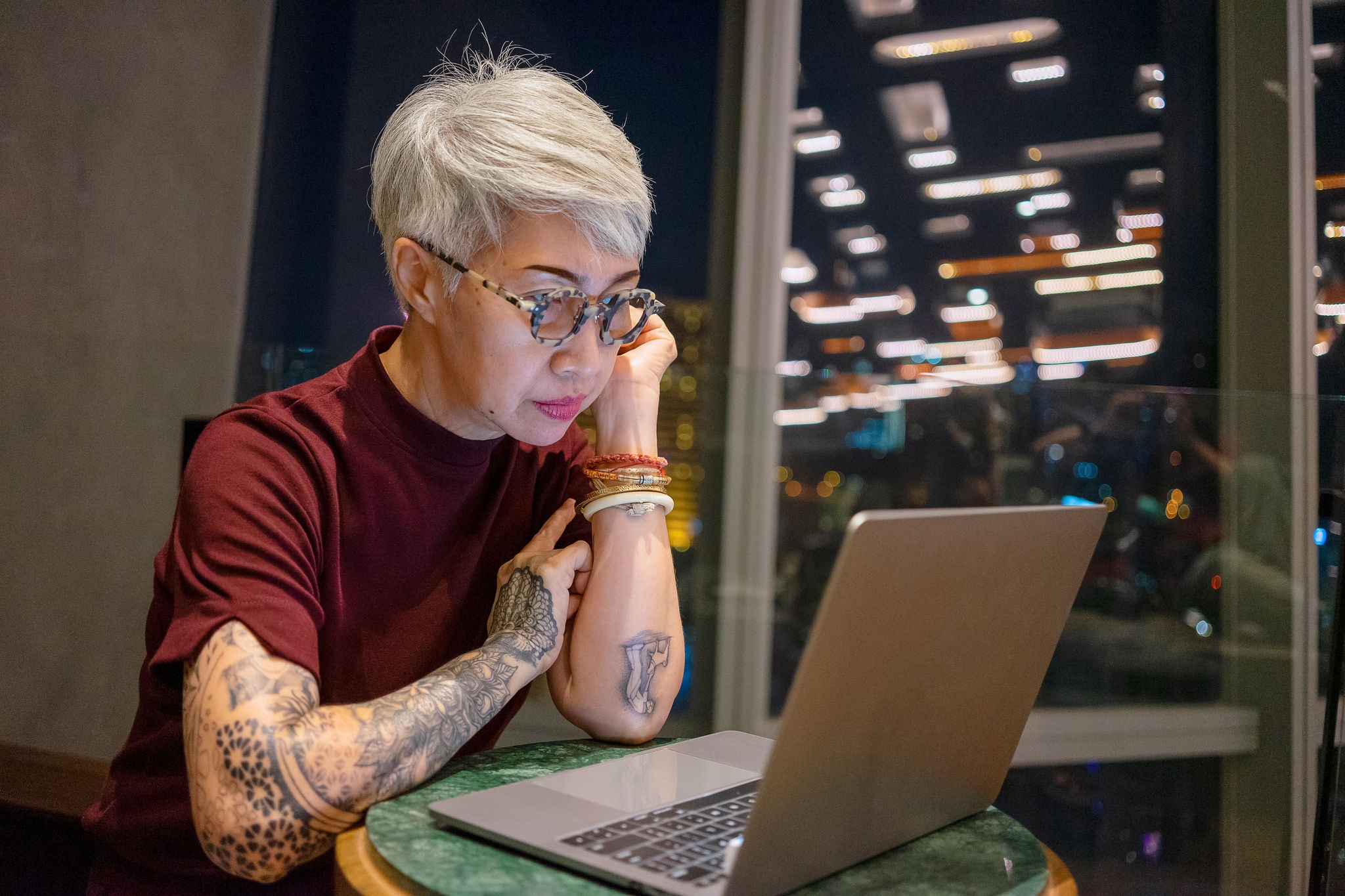 Senior woman working on laptop at night