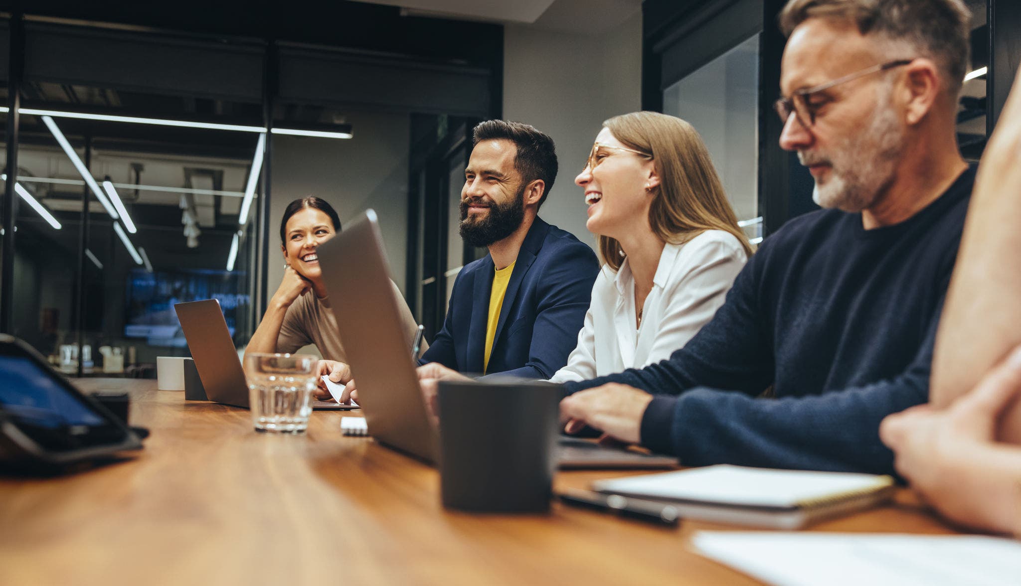 Colleagues smiling while collaborating in a meeting room