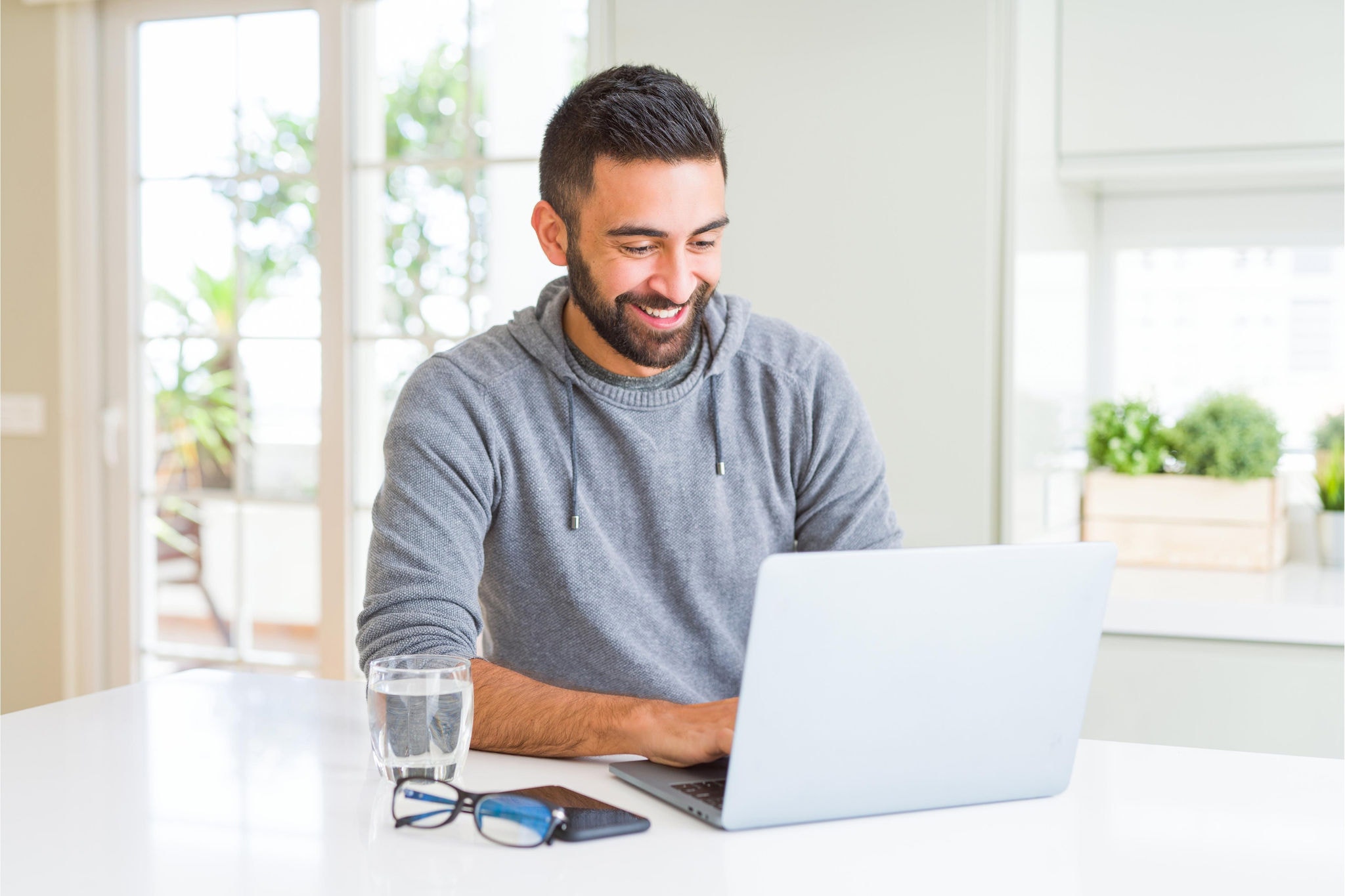 Canva-man-smiling-working-laptop