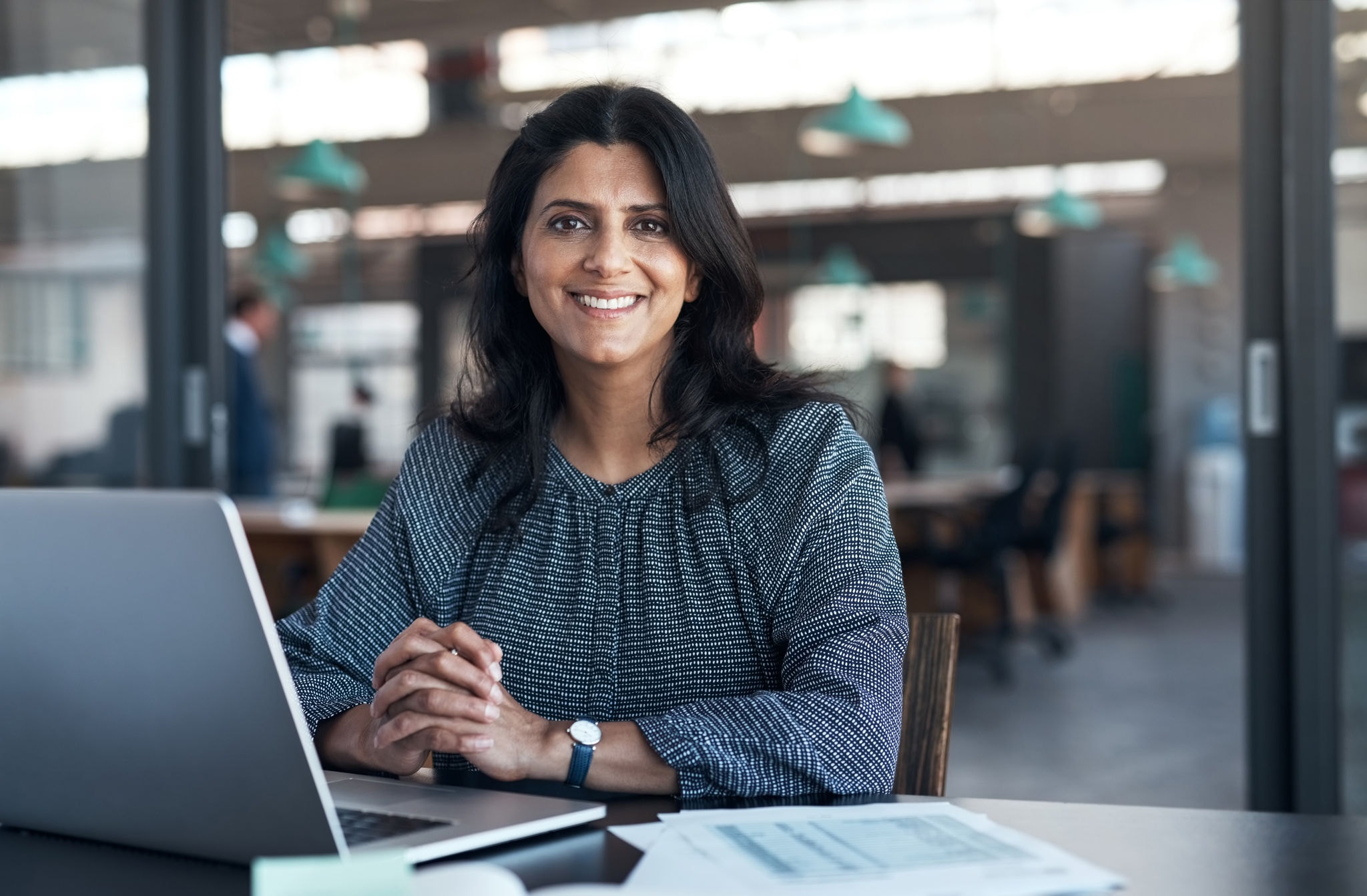 Woman working on her laptop and smiling at the camera