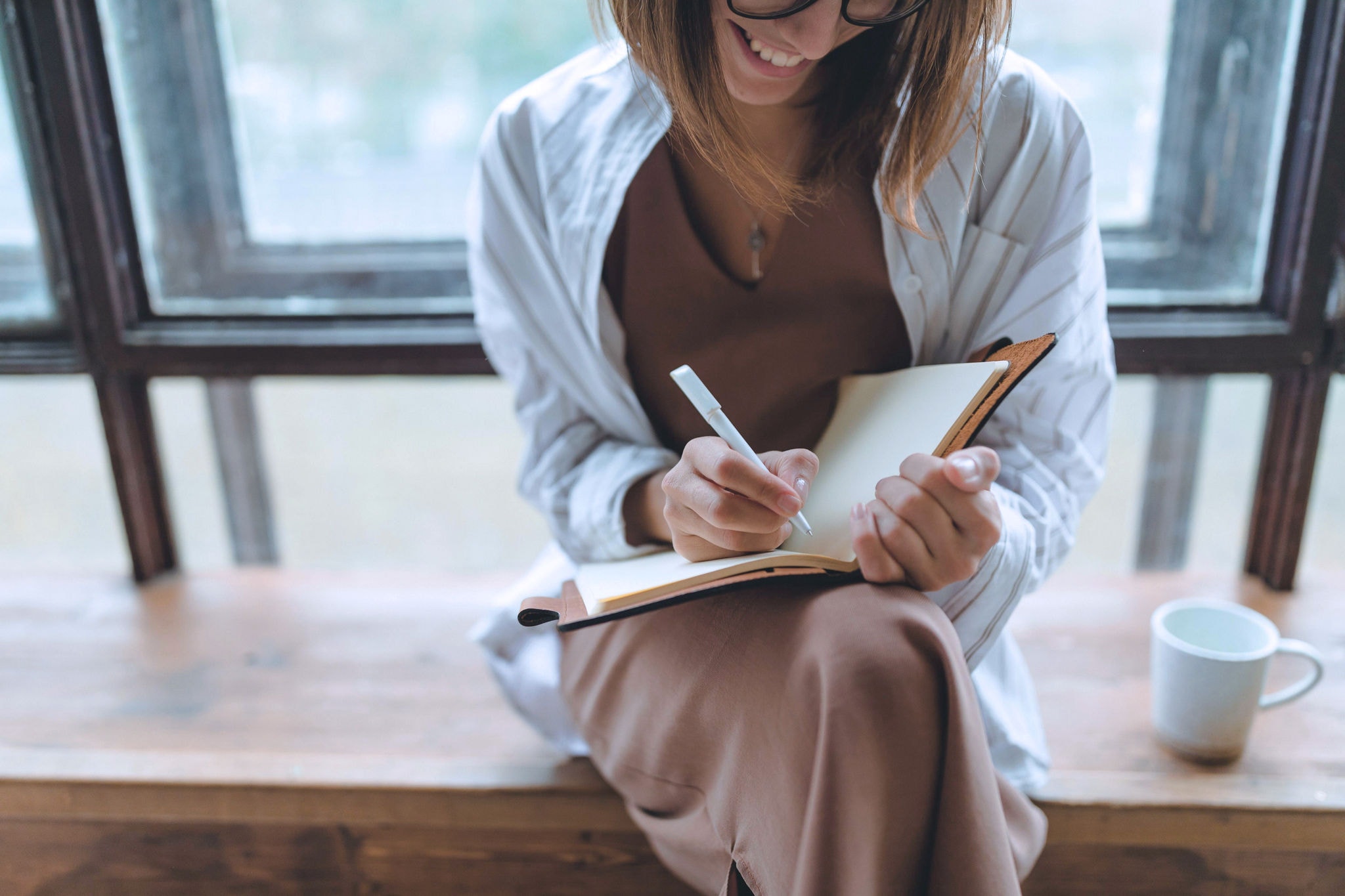 A woman writing in a notebook, making a checklist