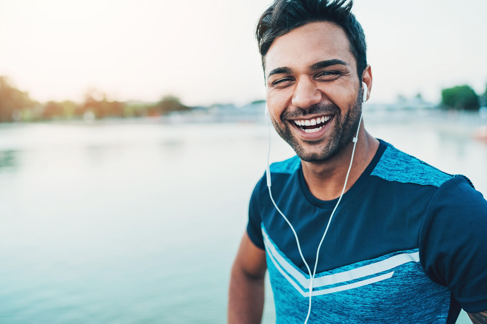 Young happy athlete by the lake