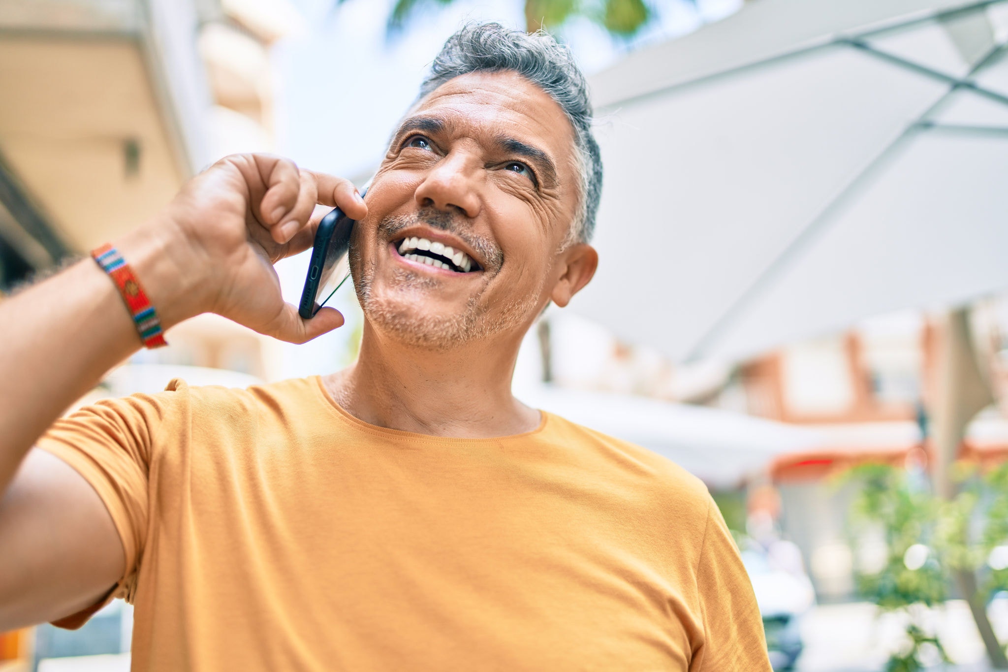 Man on holiday smiling and talking on his mobile