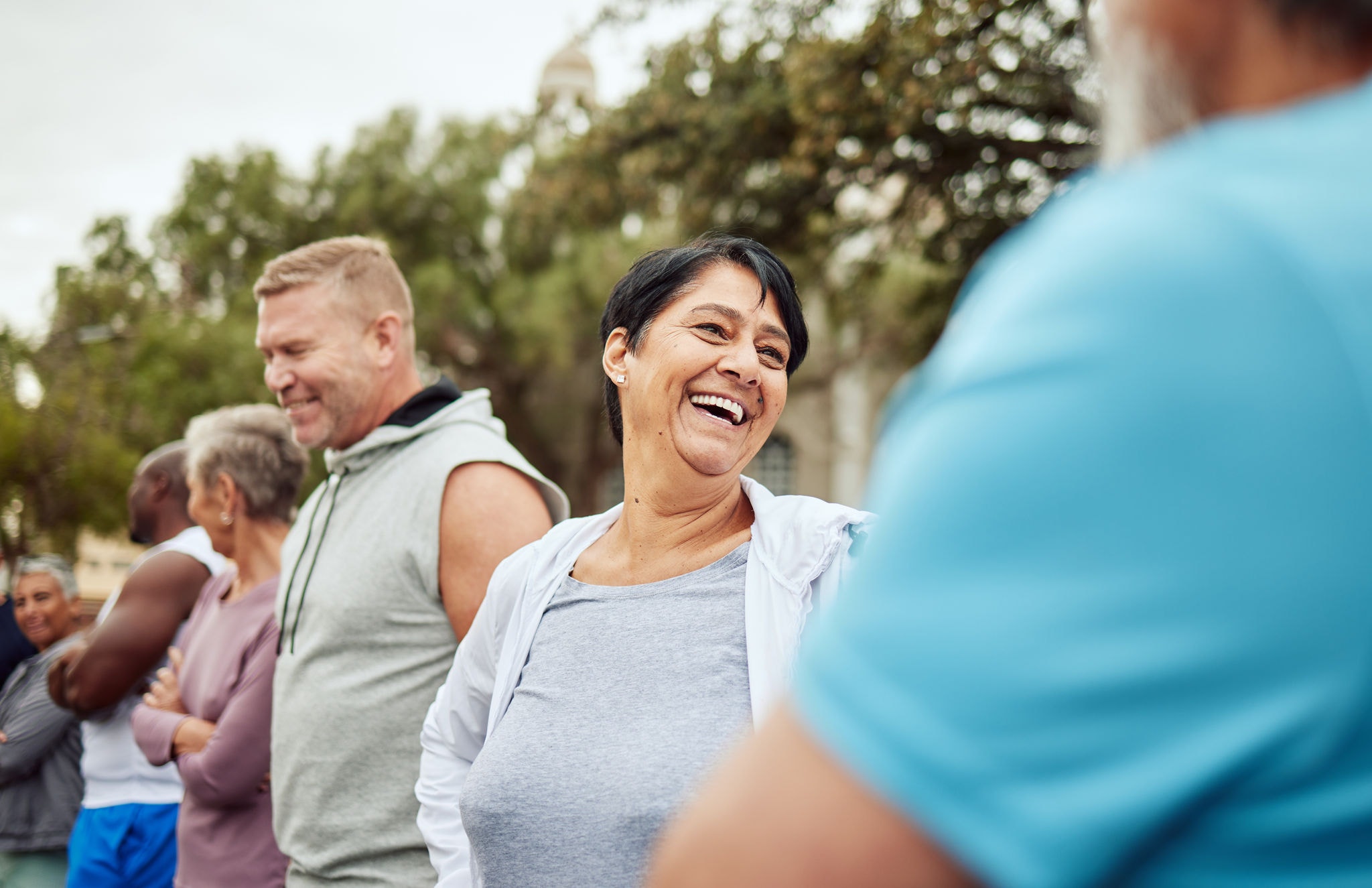 Group of friends laughing and exercising together outdoors