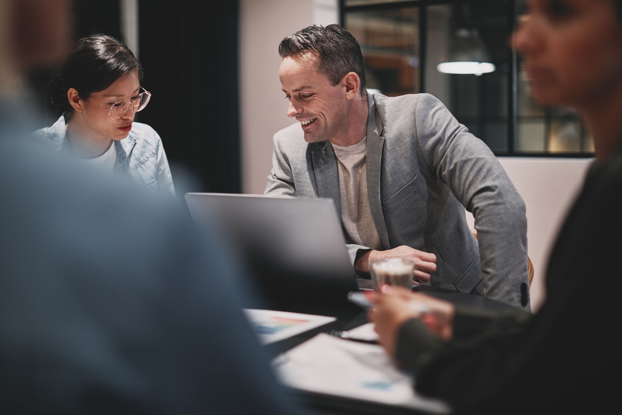 Businessman smiling while working with his colleagues around a boardroom table