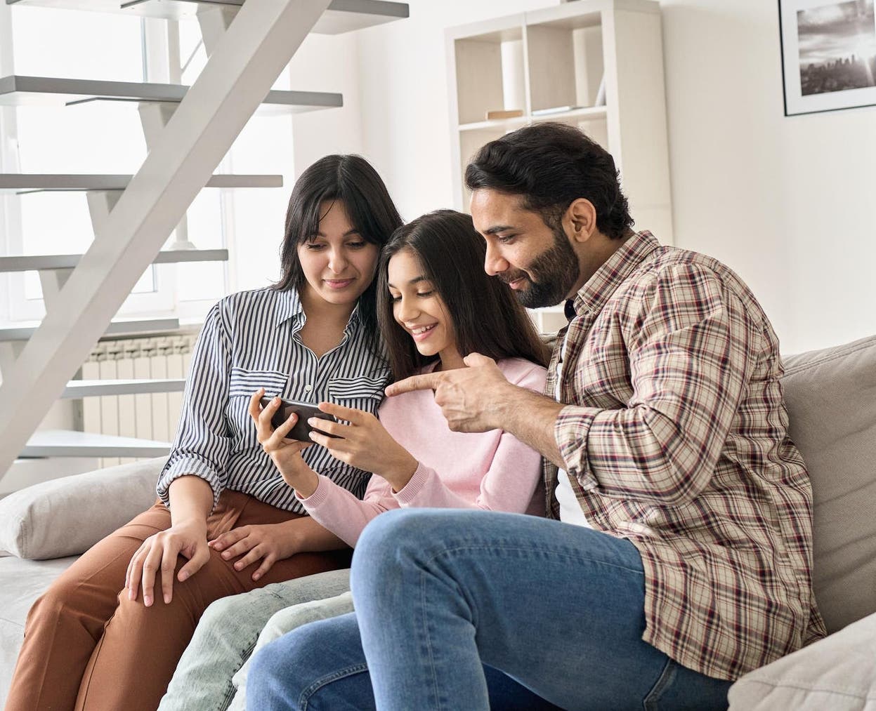 Happy family sitting on the couch and on the phone