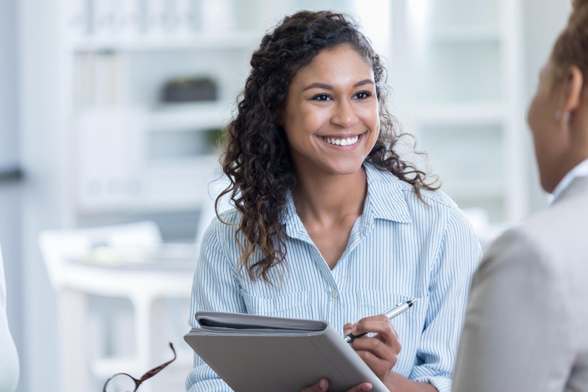 Young woman assistant in office taking notes