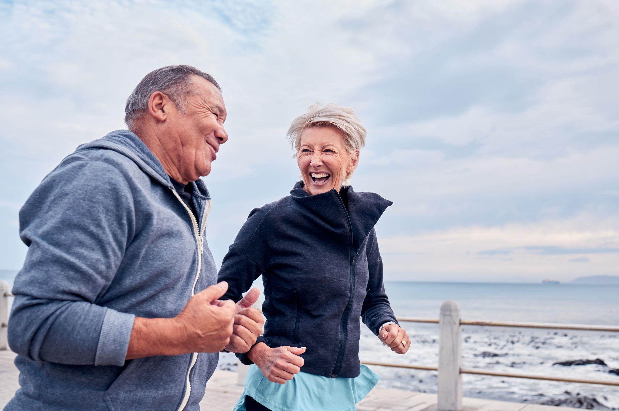 Retired couple doing a cardio workout together by the sea