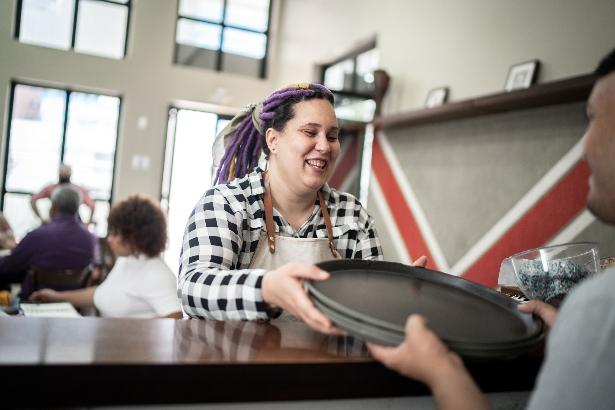 Waitress giving trays to coworker in a coffee shop