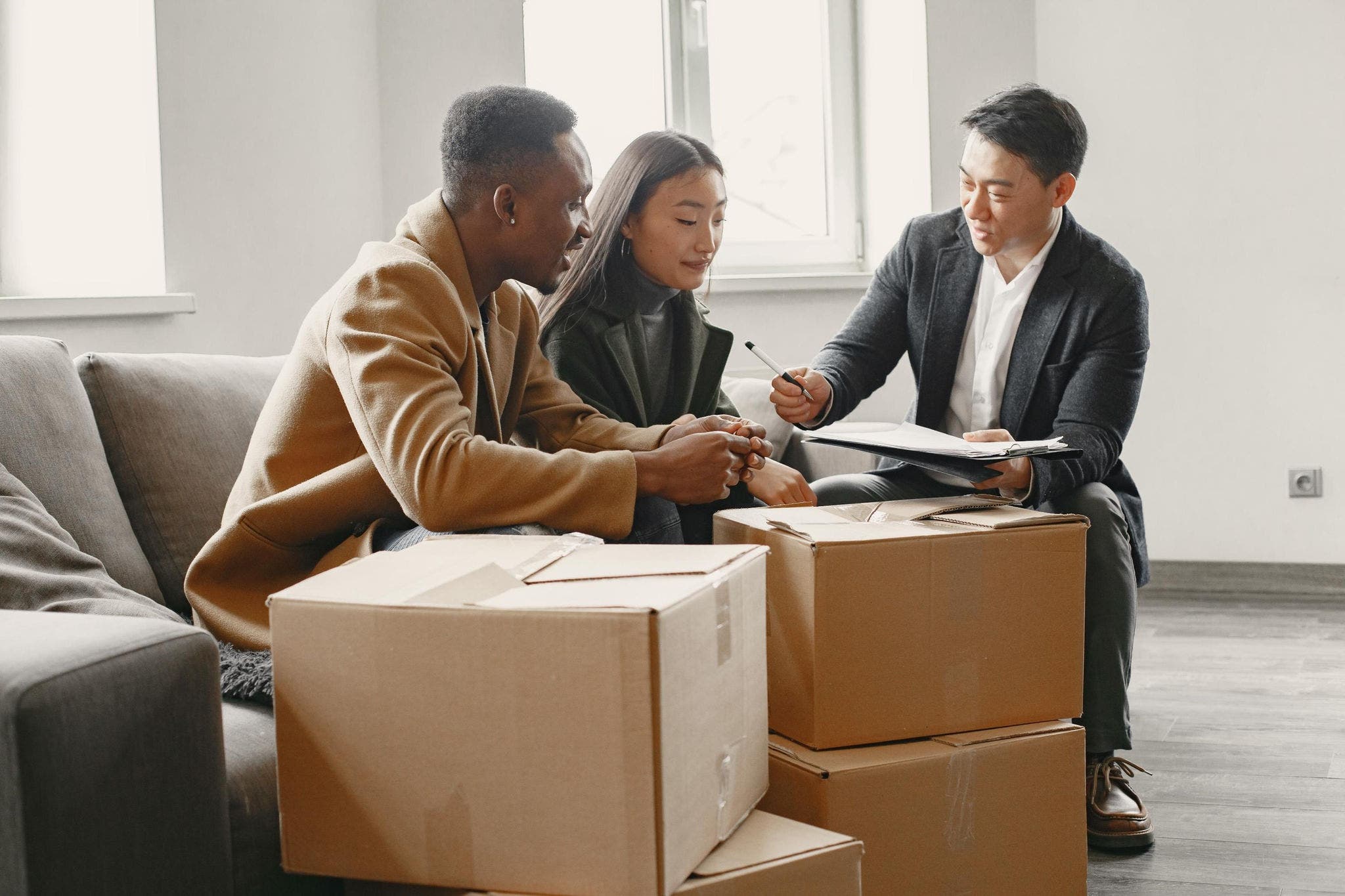 Couple at home signing a contract with male adviser 