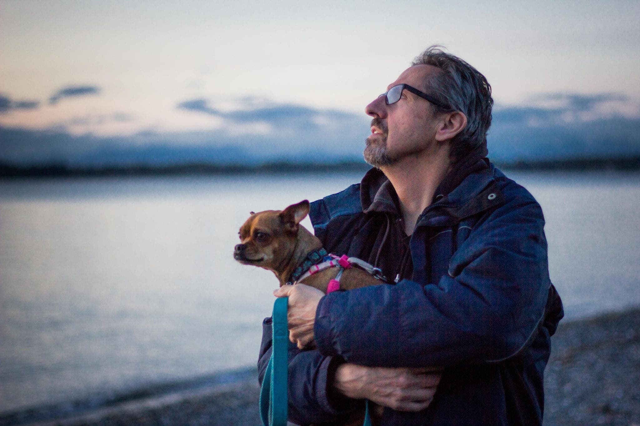 A mature man enjoying time at the beach with his dog
