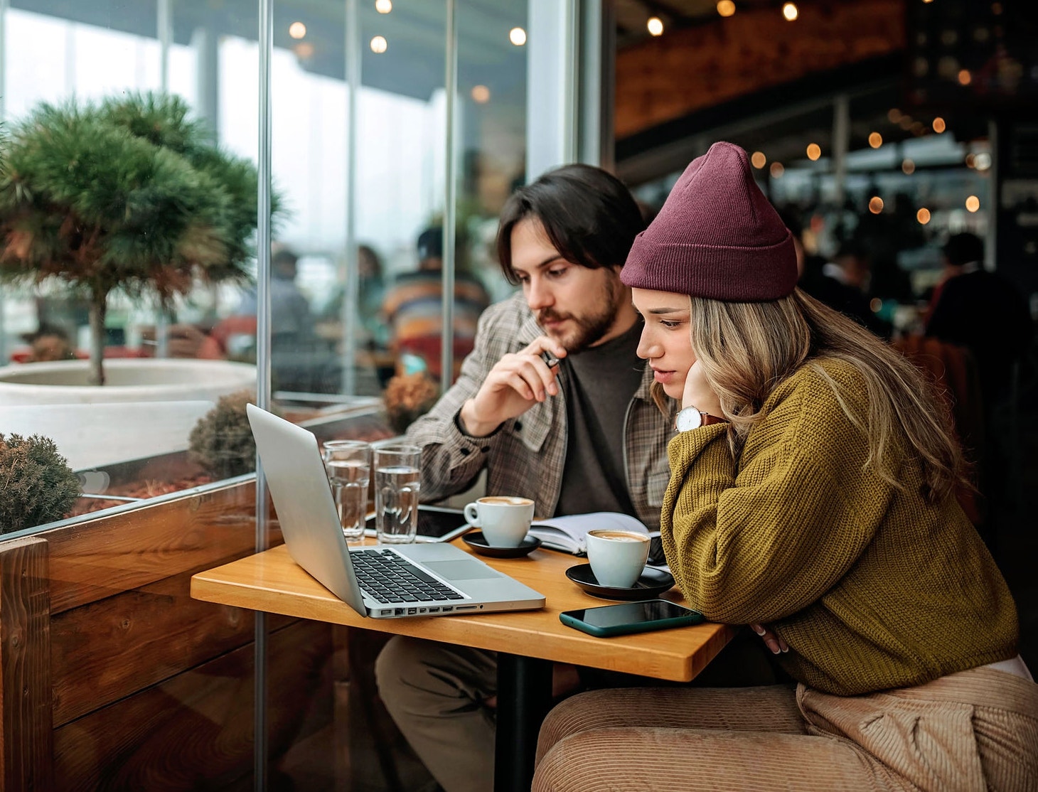 Young couple doing freelance work in cafe