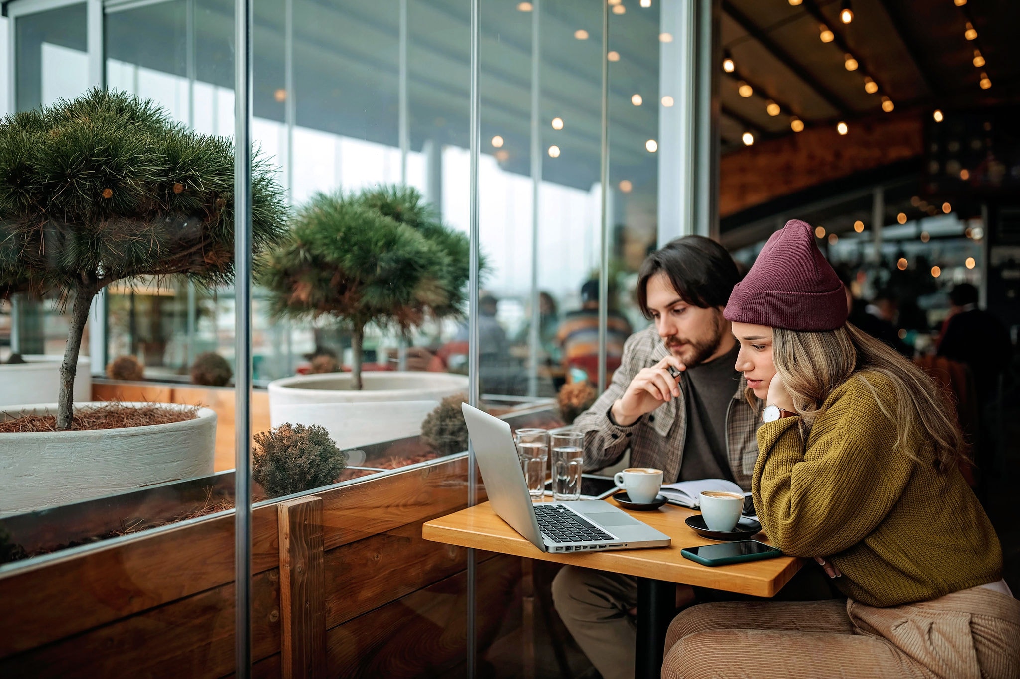 Young couple doing freelance work in cafe