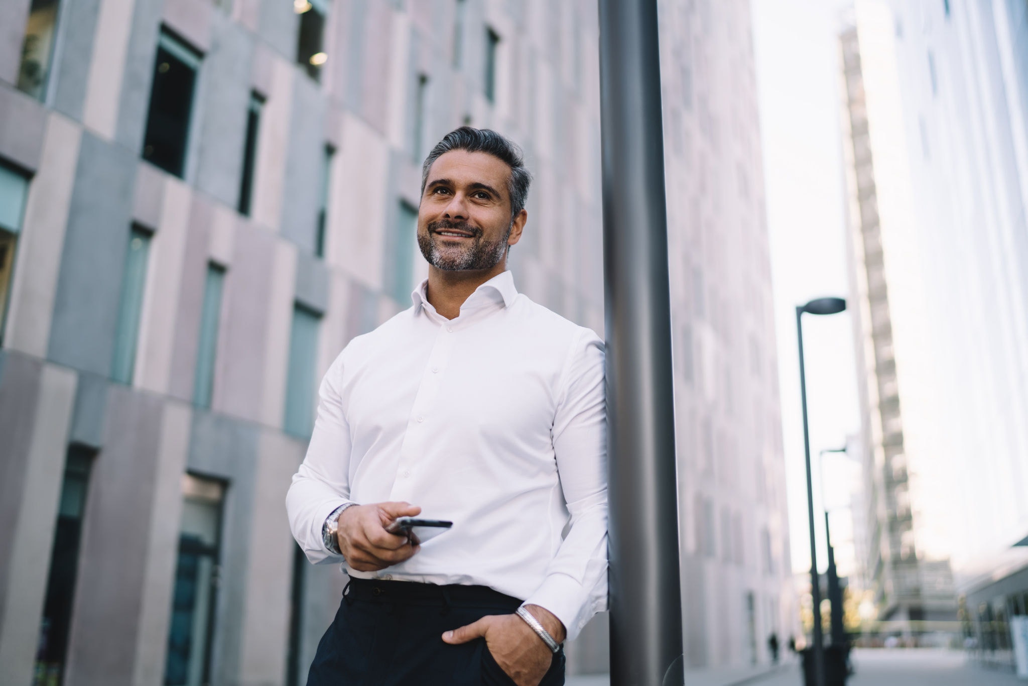 Corporate director in formal white shirt holding his mobile