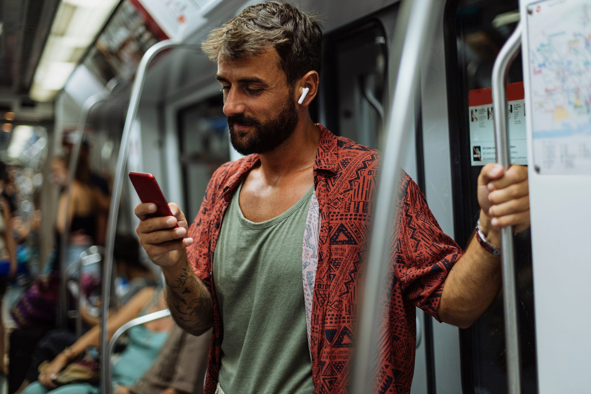 Young man using his mobile phone while riding a subway train