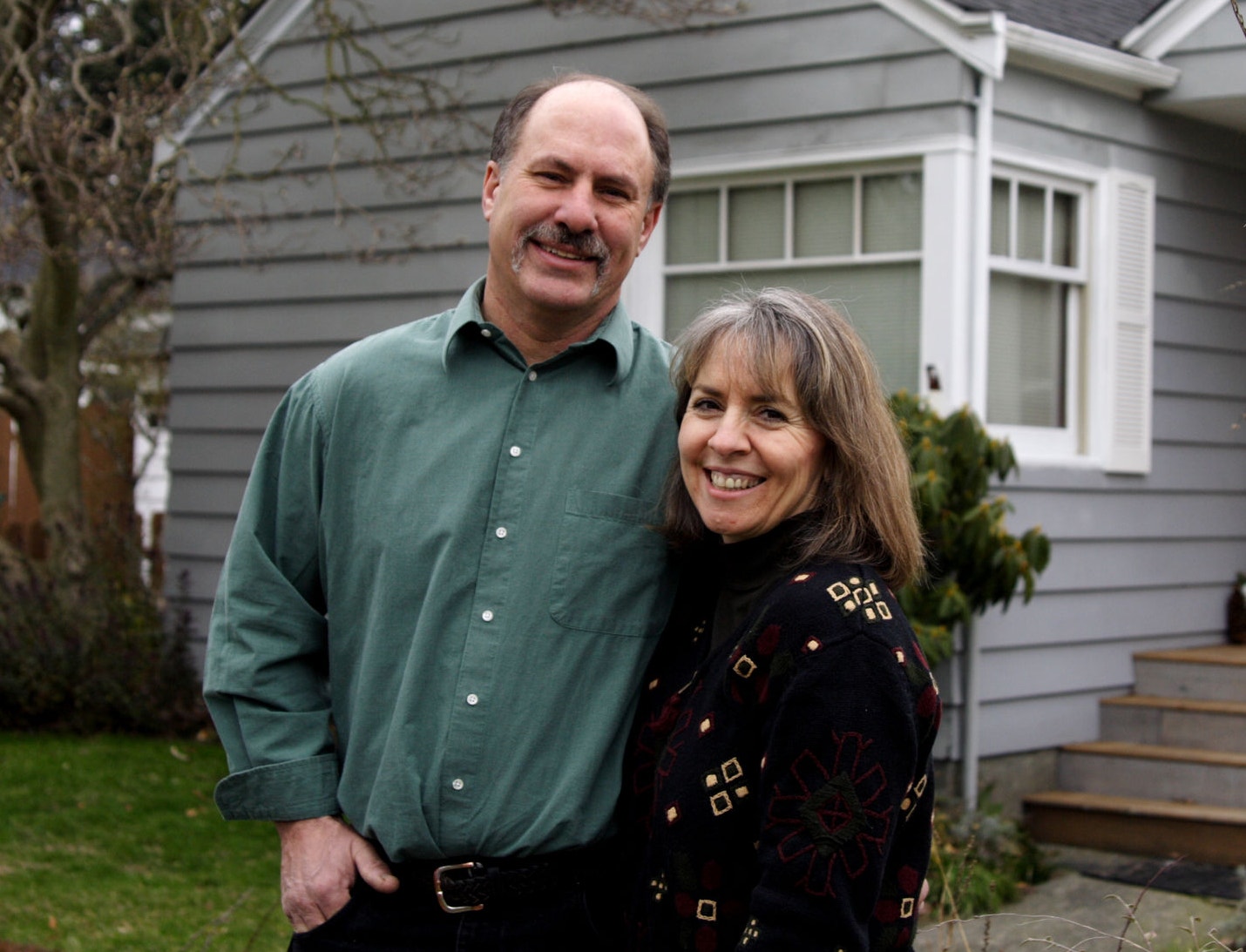 mother and father in front of home