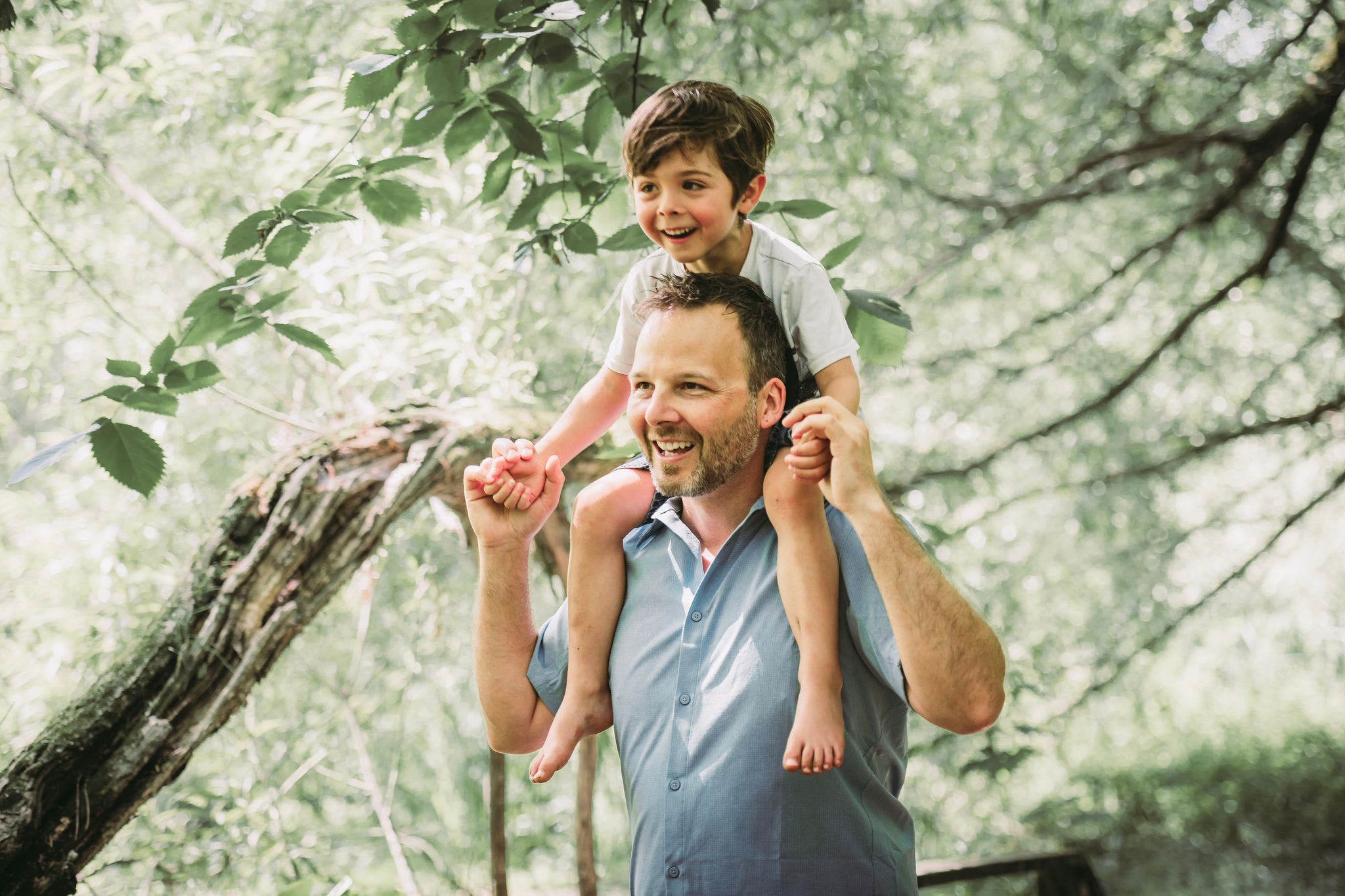 A father with his little boy playing with him in nature.