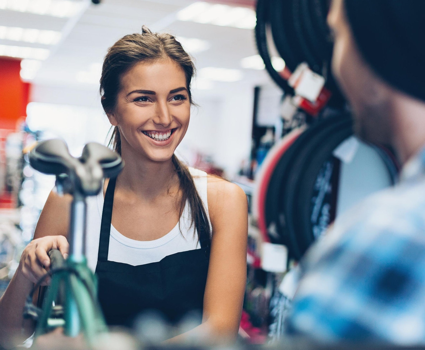canva-shop-assistant-bike-shop-smiling-woman