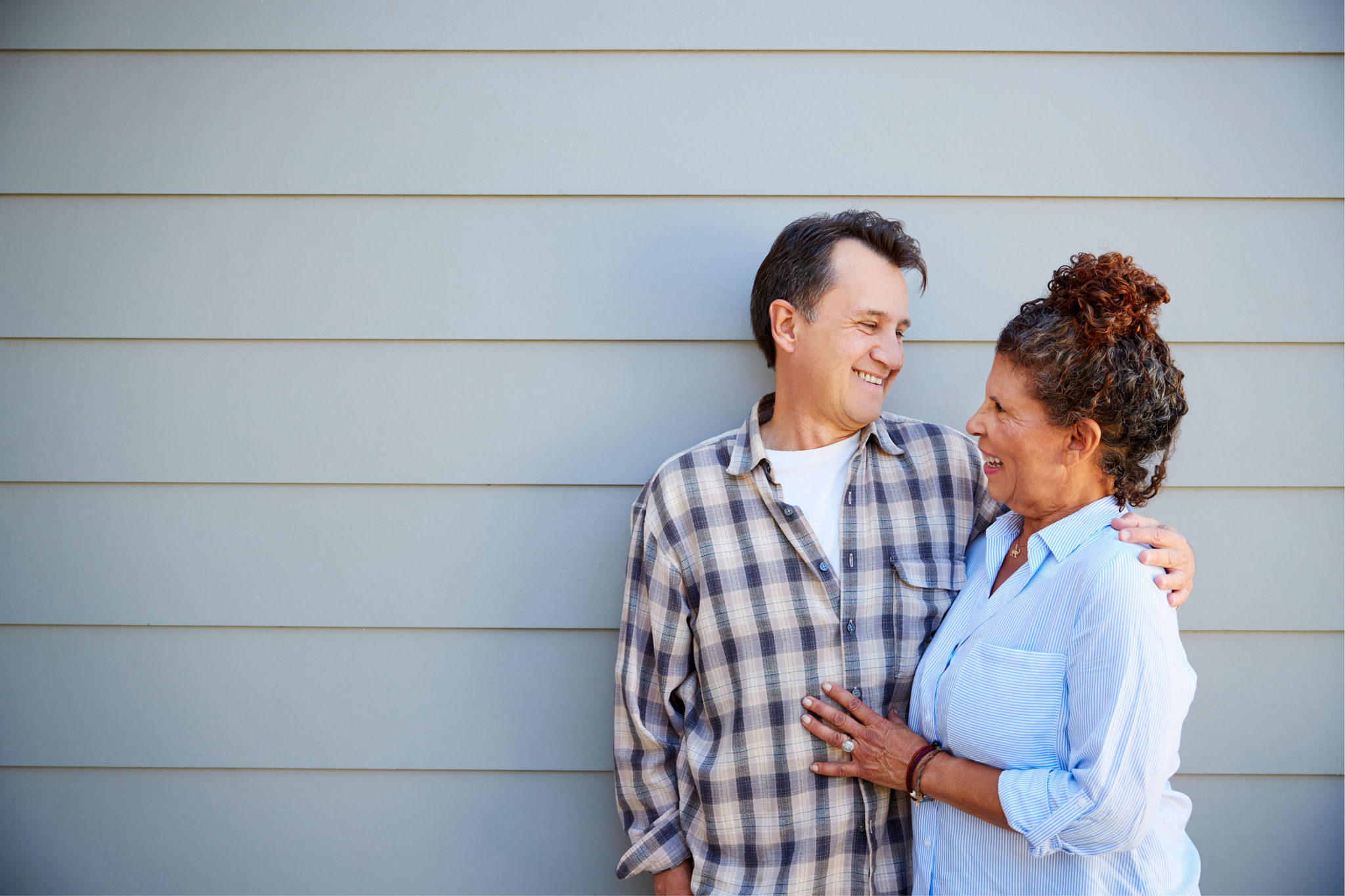 Couple posing in front of weatherboard house
