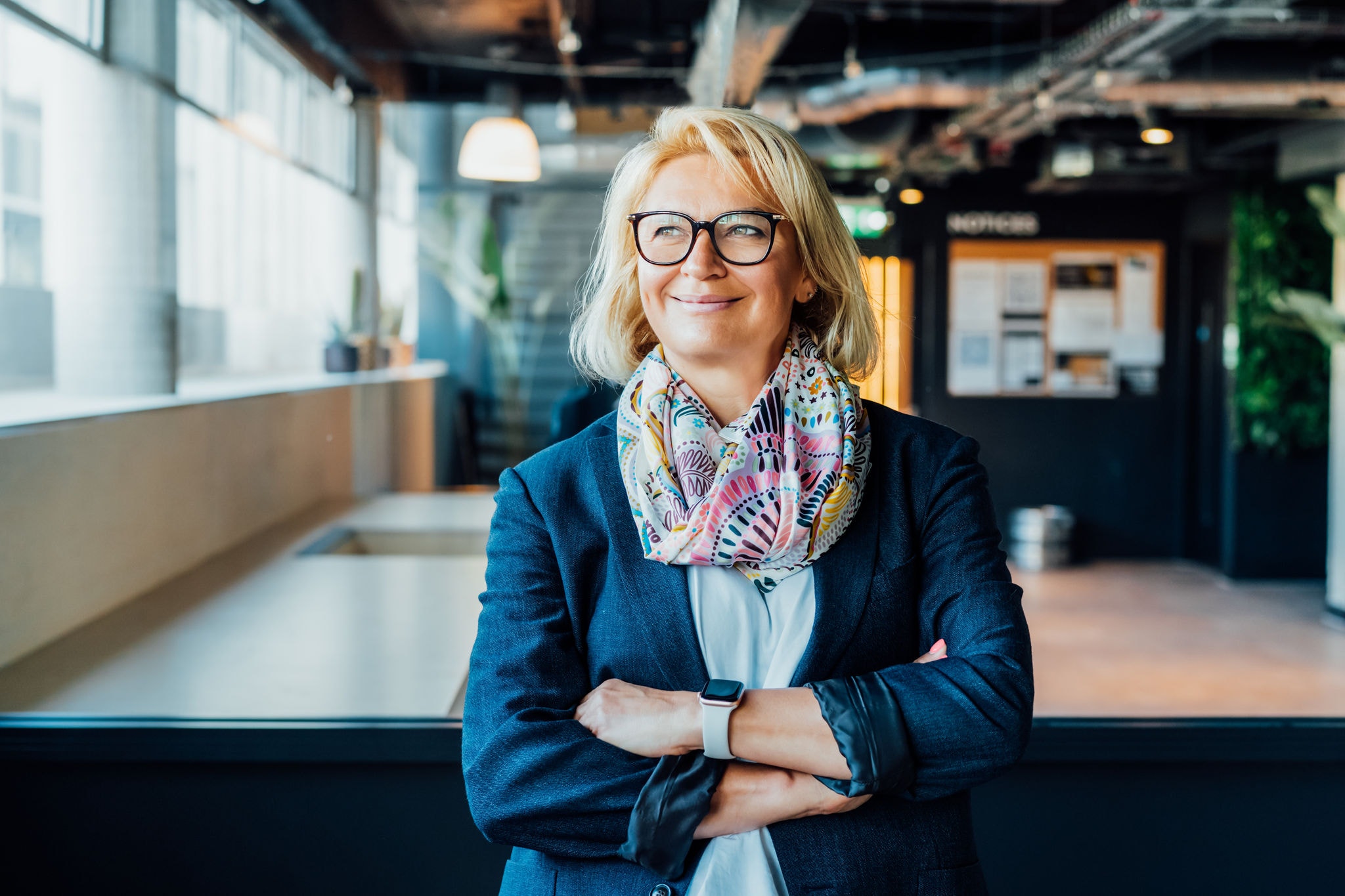 Feamel team leader smiling with her arms crossed in a modern office