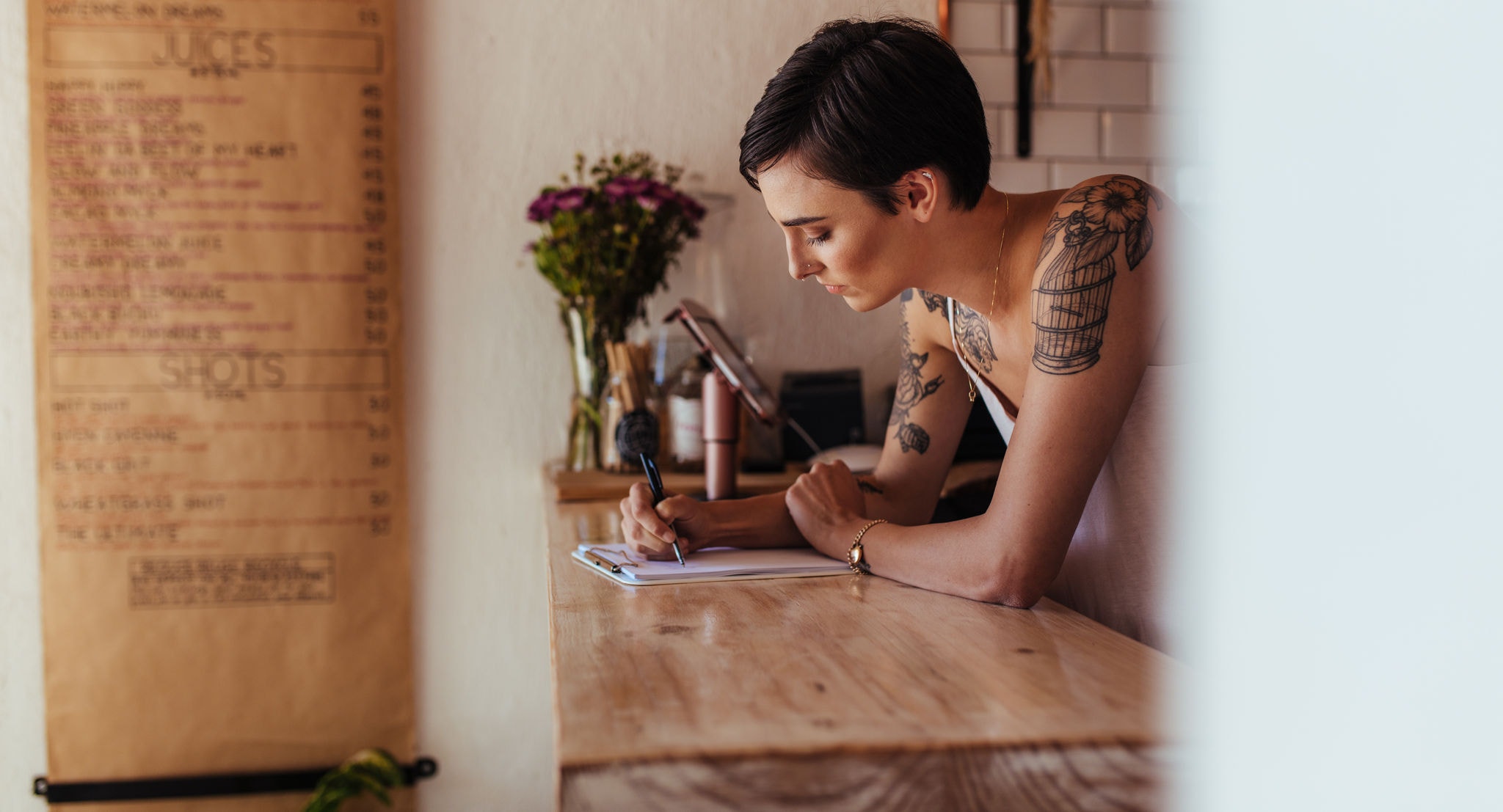 Owner standing at the billing counter of her cafe taking orders