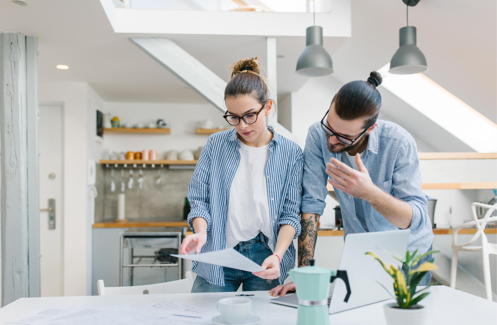 A young couple reviewing paperwork in a modern house