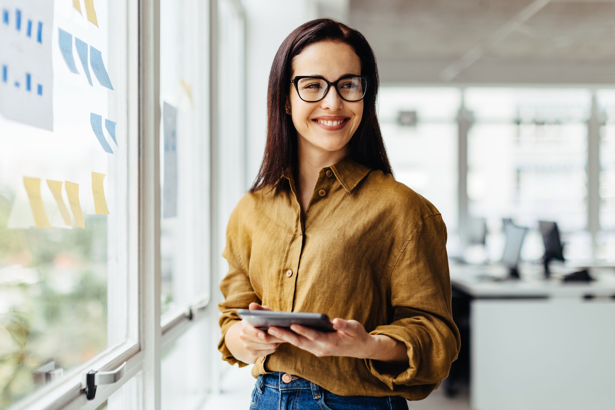 Business woman holding a tablet in an office